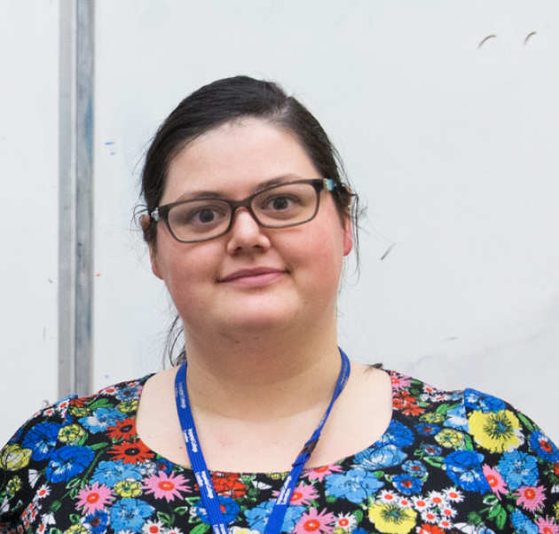 woman in floral top with blue lanyard