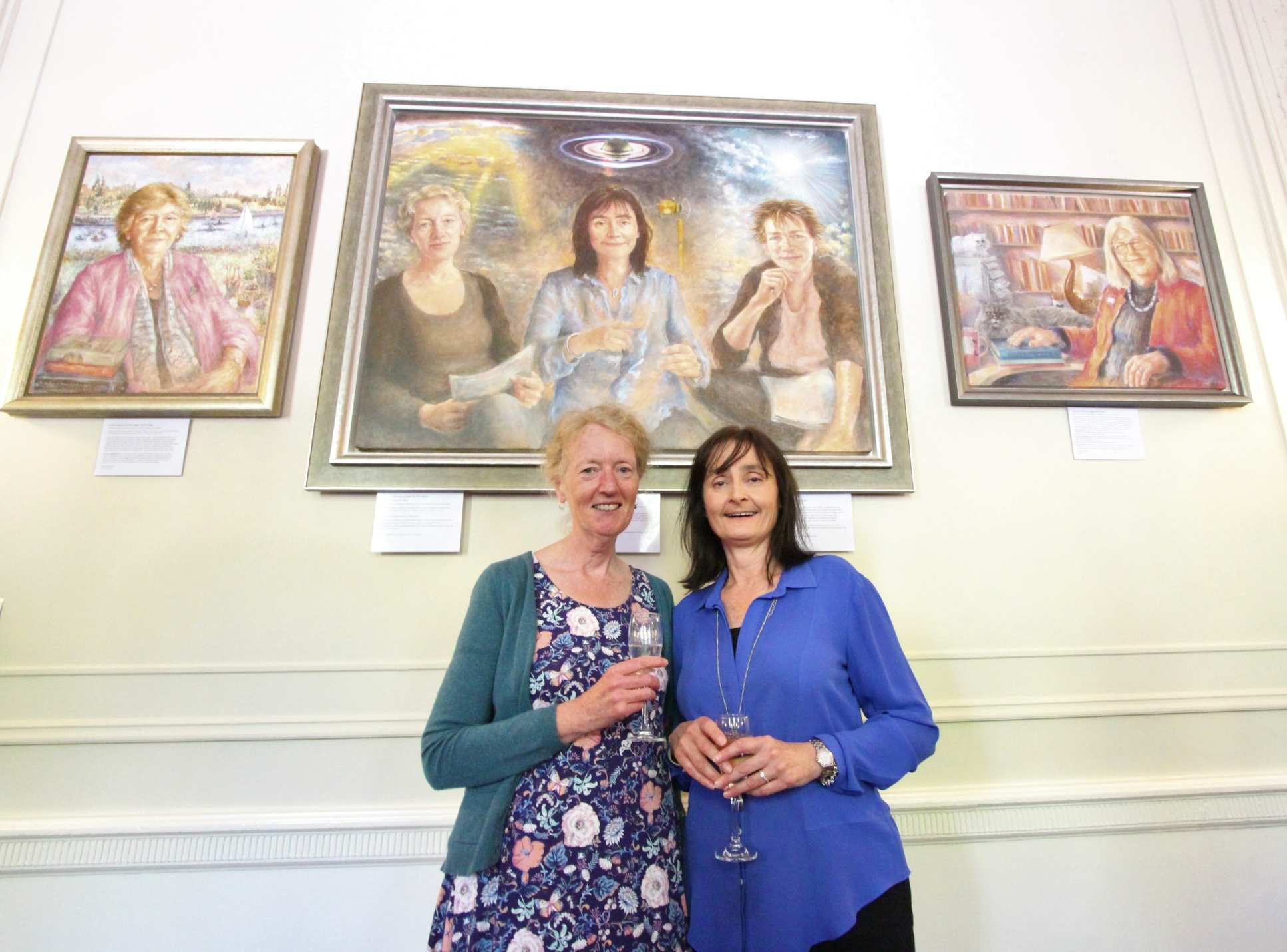 Celebrated Imperial women stand in front of their portraits