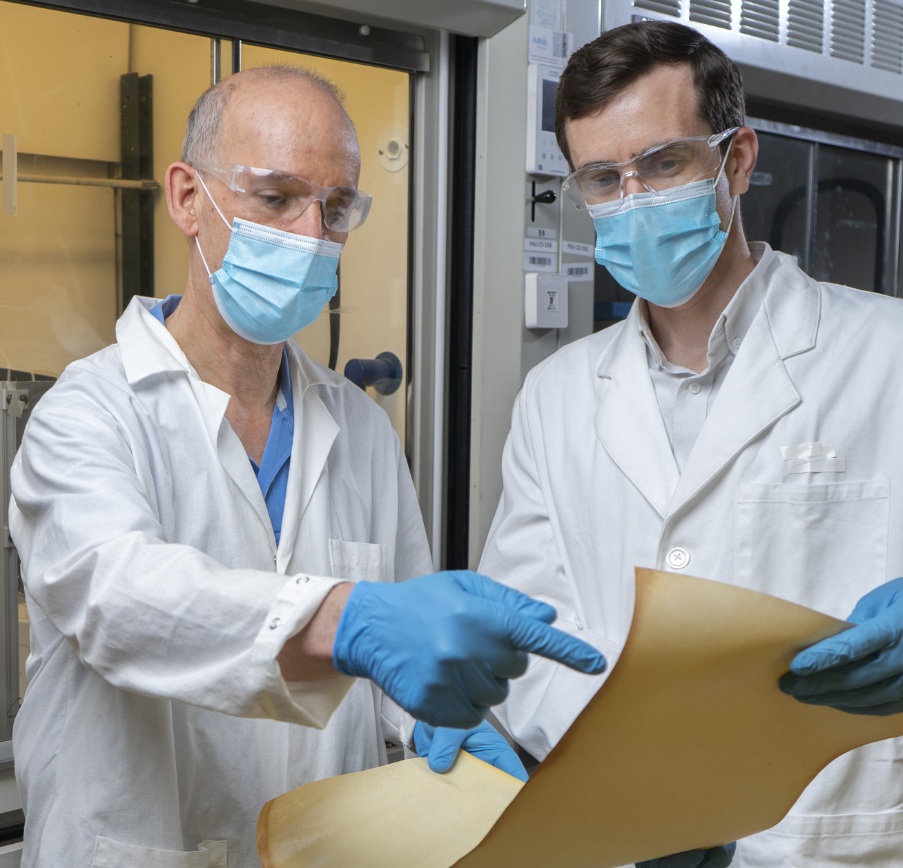 Two male academics holding the membrane