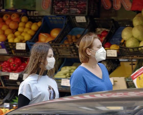 2 ladies with masks in a market