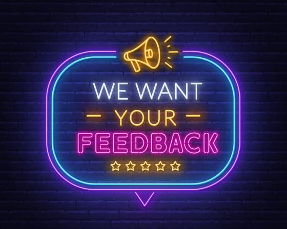 Neon sign: "We want your feedback".
