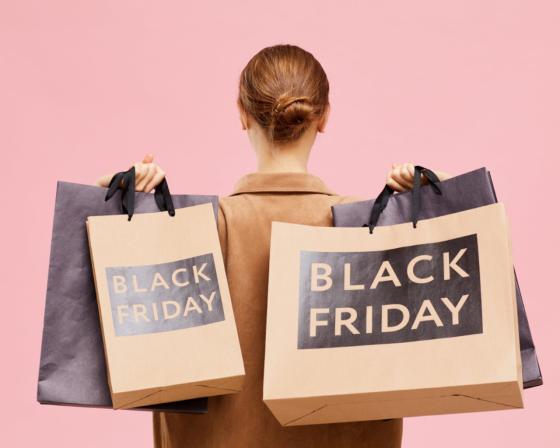 A woman holding shopping bags marked "Black Friday"