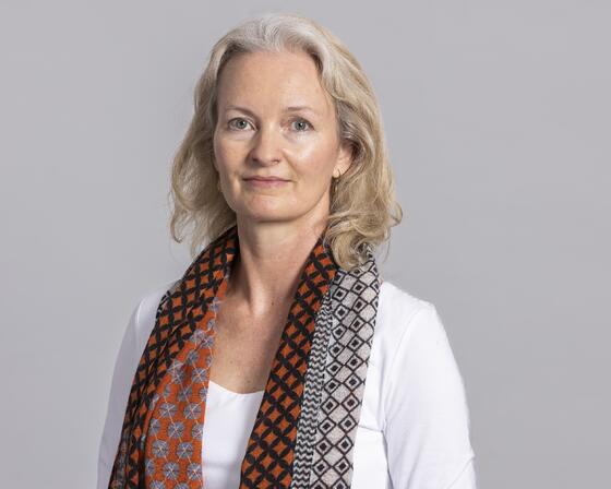 Picture of Pernille Holtedahl wearing a white top and colourful scarf around her neck. 