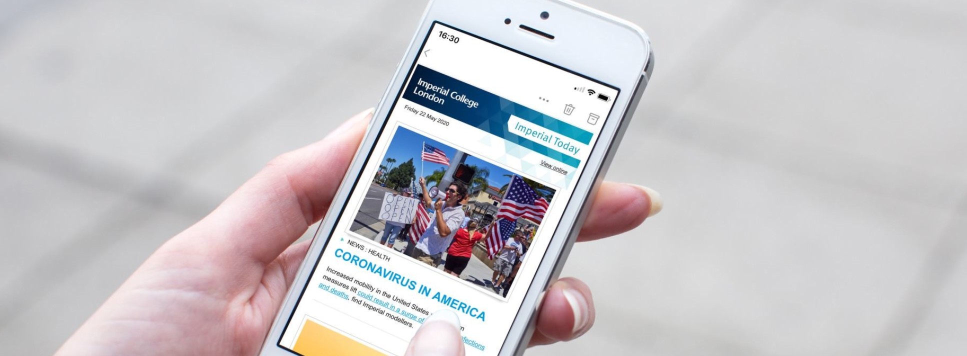 Image of a person browsing the Imperial news website on their phone