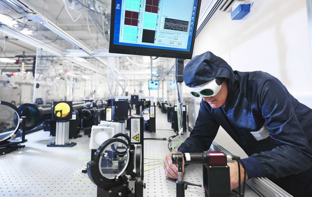 Researcher in laser goggles adjusting equipment