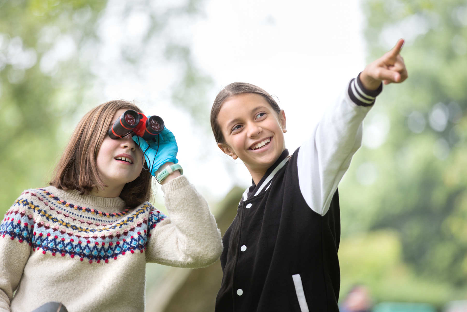 Two children looking through binoculars