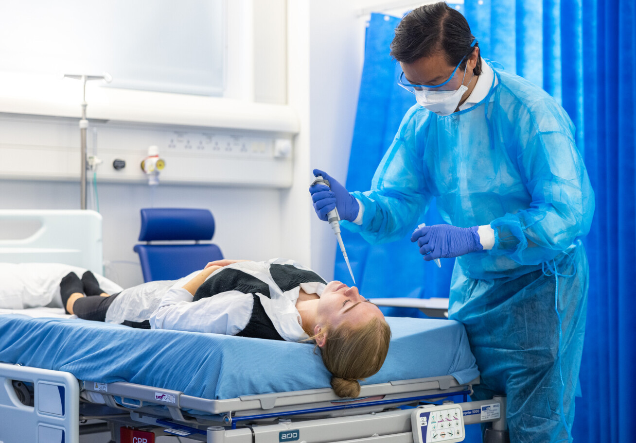 Professor Christopher Chiu, Professor of Infectious Diseases, demonstrating how SARS-CoV-2 virus is injected into a volunteer's nostril as part of the human challenge trial