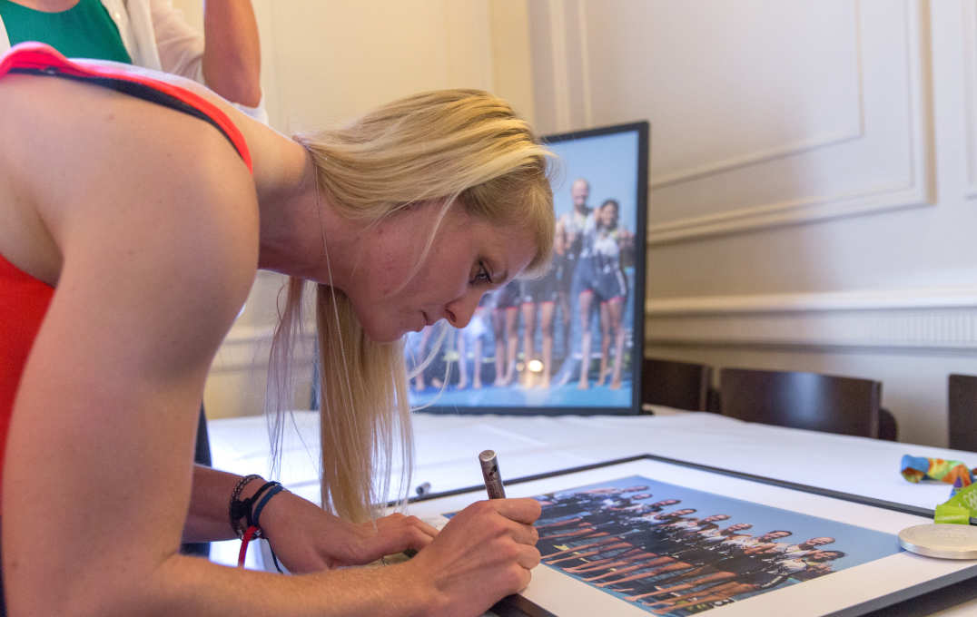 Woman with pen in hand signing photo