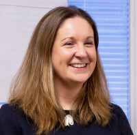 Headshot of Dr Caroline Howe speaking at an event 