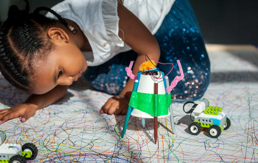 A child looking at her Scribblebot