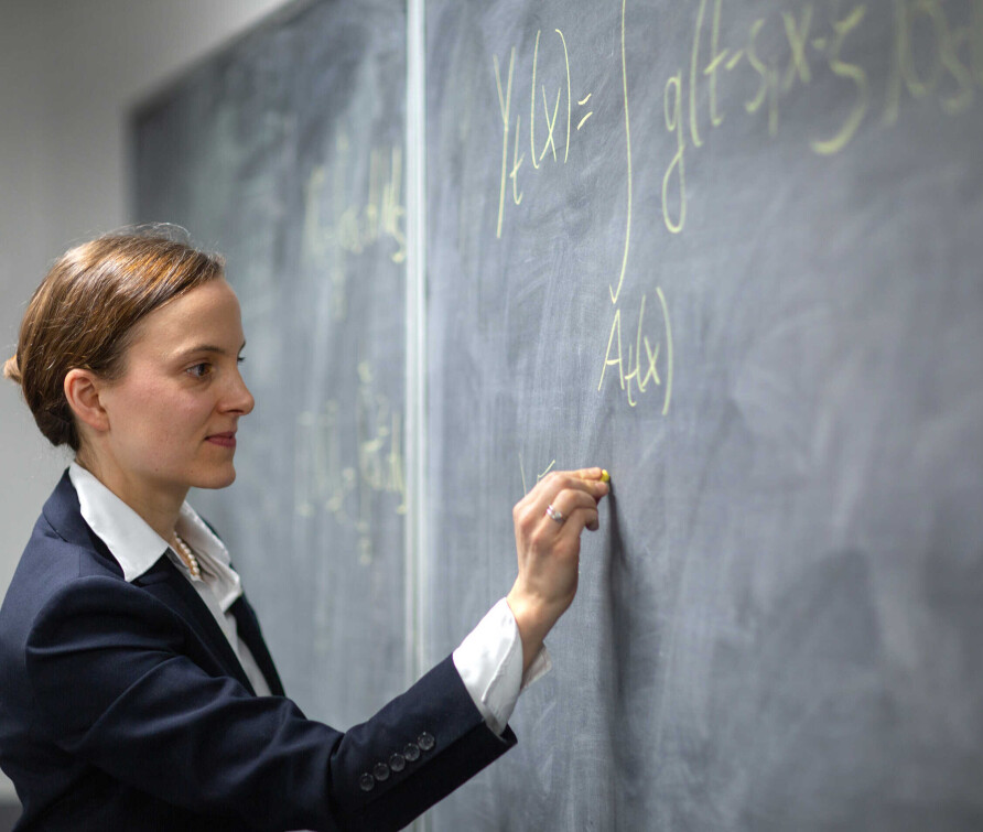 Professor Almut Veraart writing on blackboard