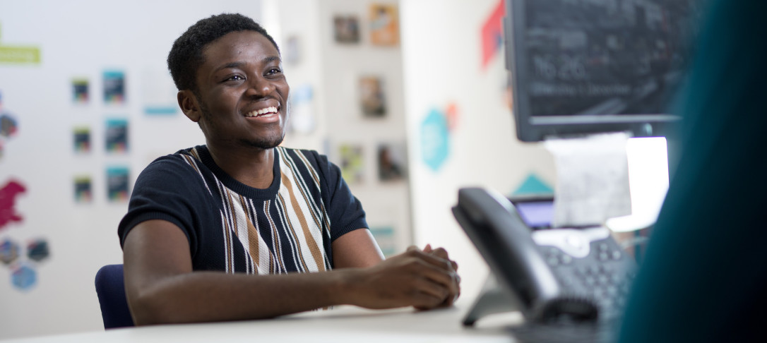 Black student smiling at desk