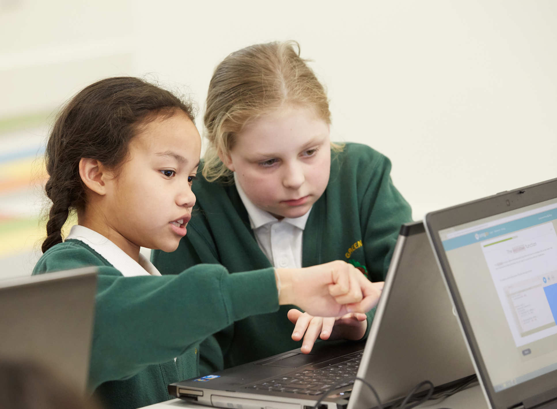 two girls focus on a laptop screen image 