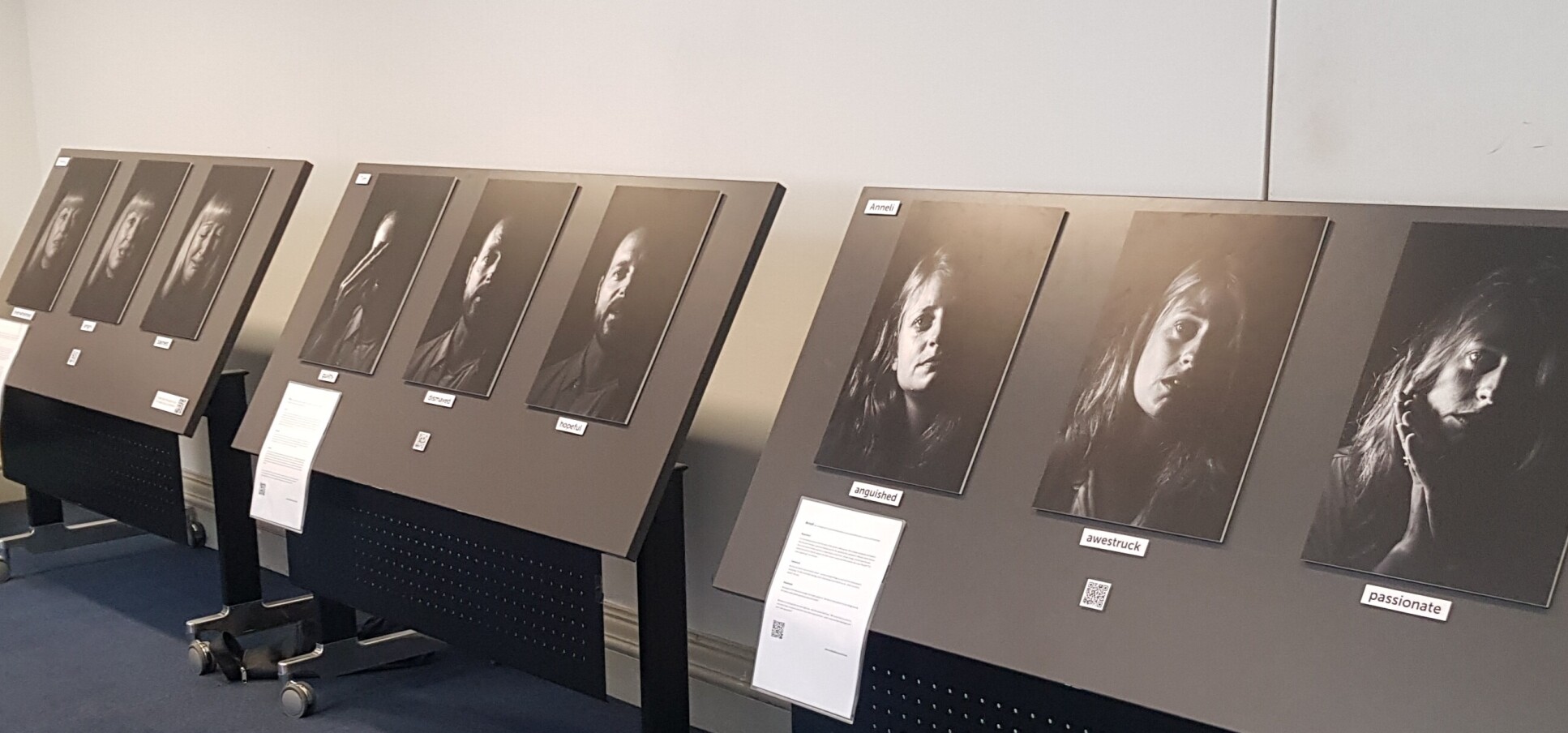 Black and white photos of faces in exhibition