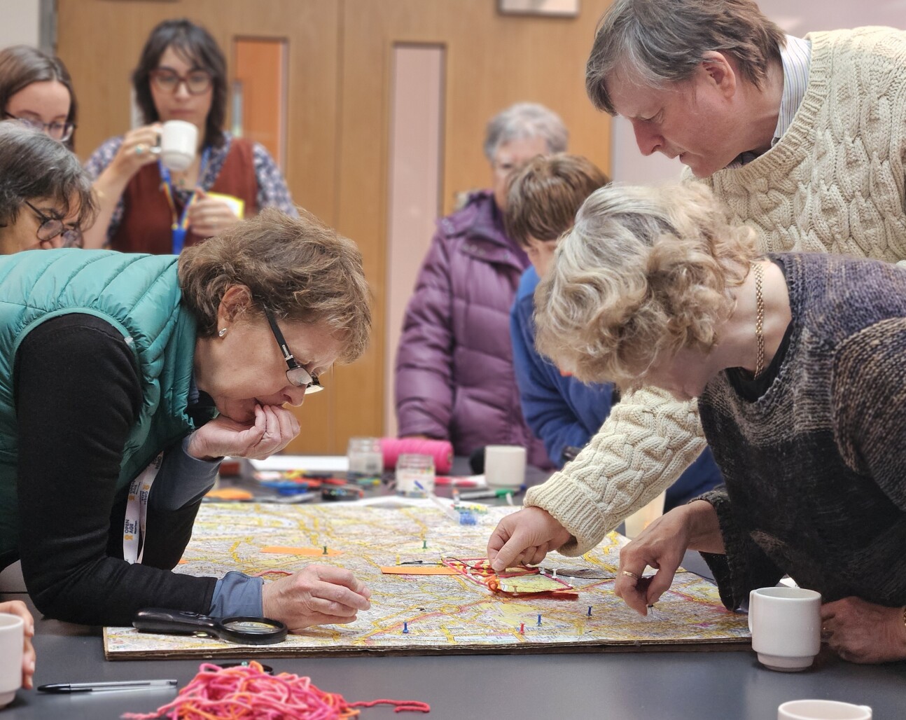 attendees leaning over a table to complete an activity as part of the visit.