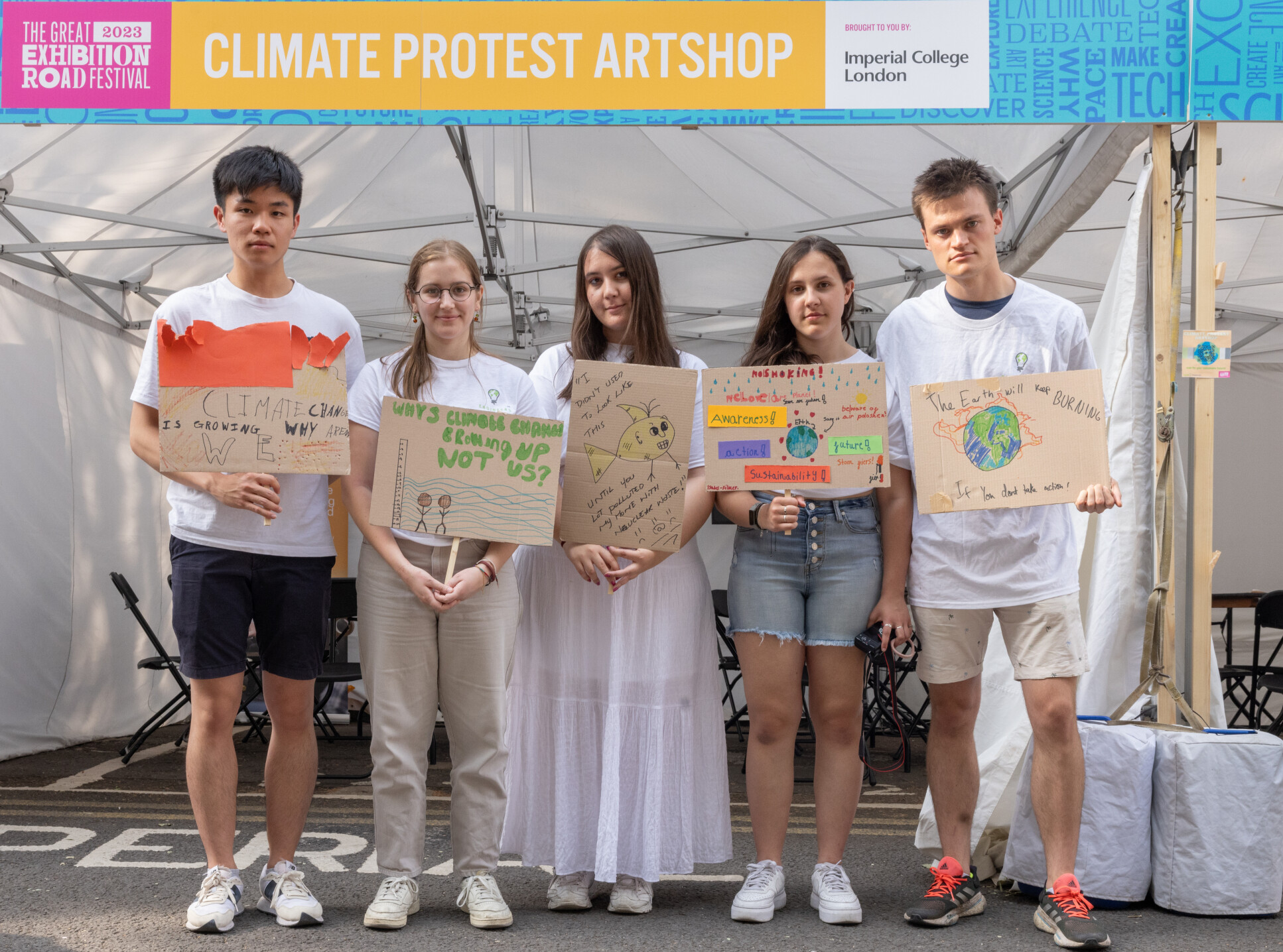 Five young people hold up their placards