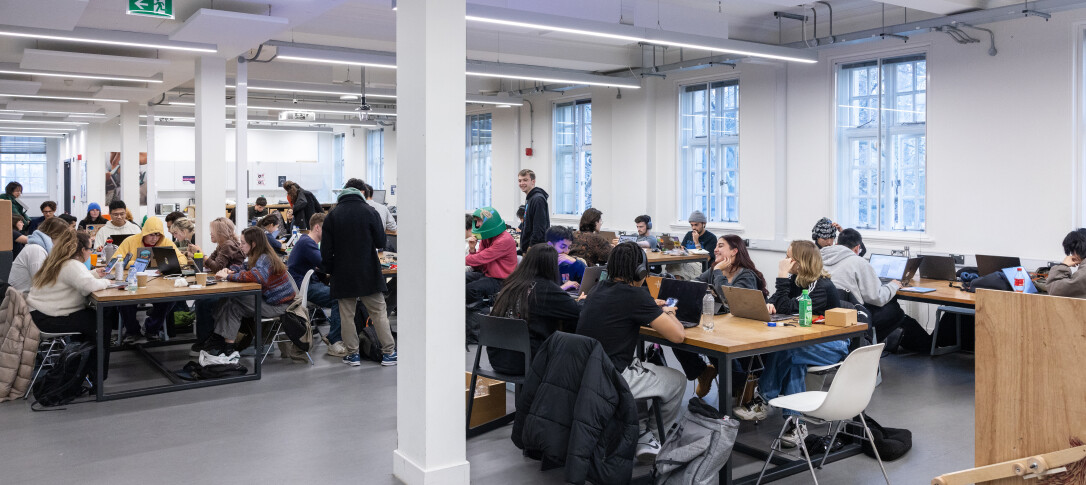 A learning/teaching space in the Dyson School of Dyson Engineering filled with students, with big light filled windows  