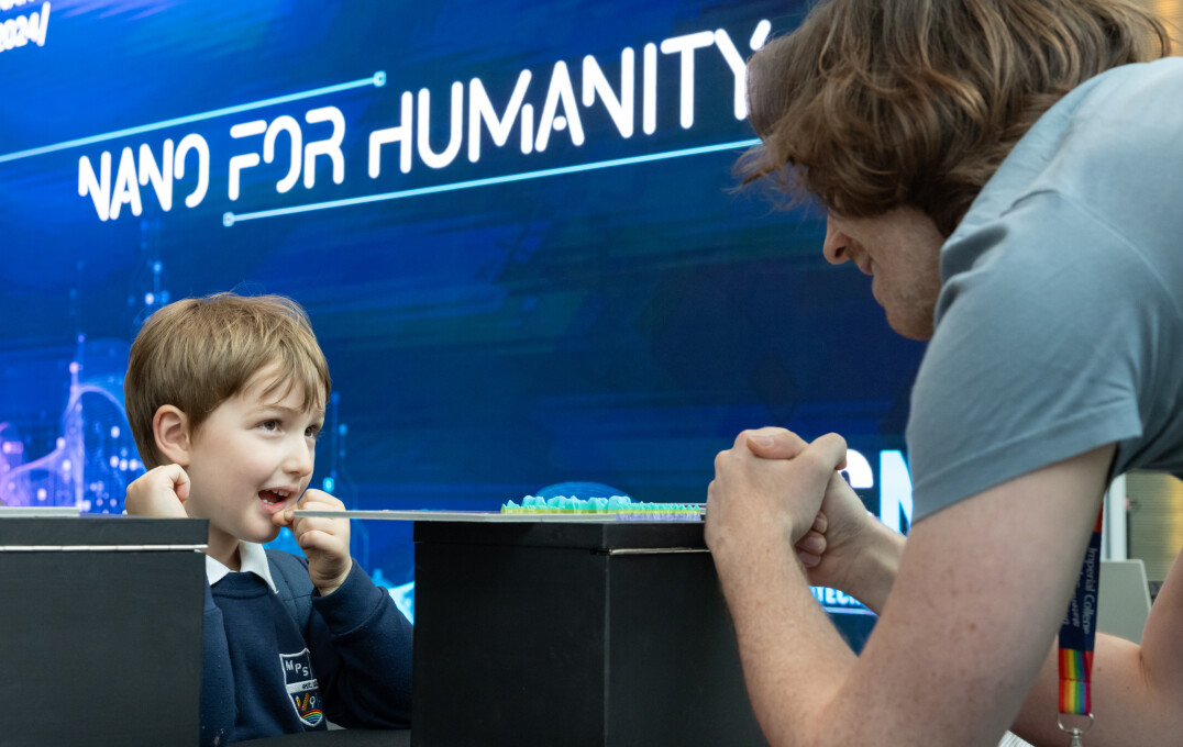 A child talking to a researcher at an exhibit