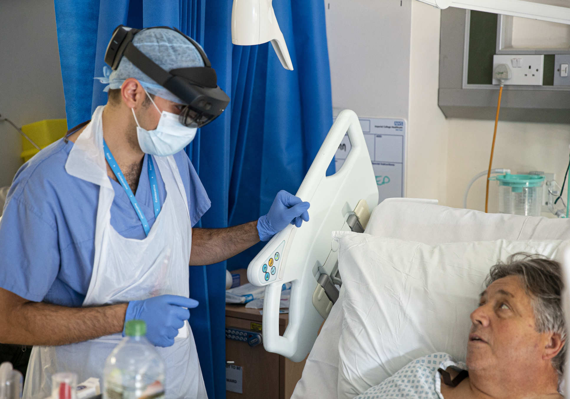 A photograph of a doctor wearing HoloLens, talking to a patient