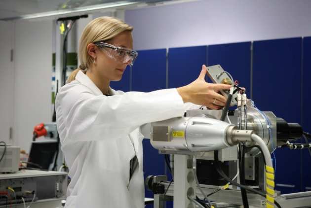 Dr Claire Stanley adjusting equipment in a laboratory