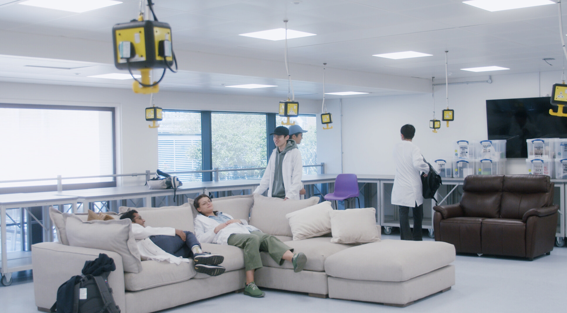 Imperial students sitting on a sofa in a lab-style setting