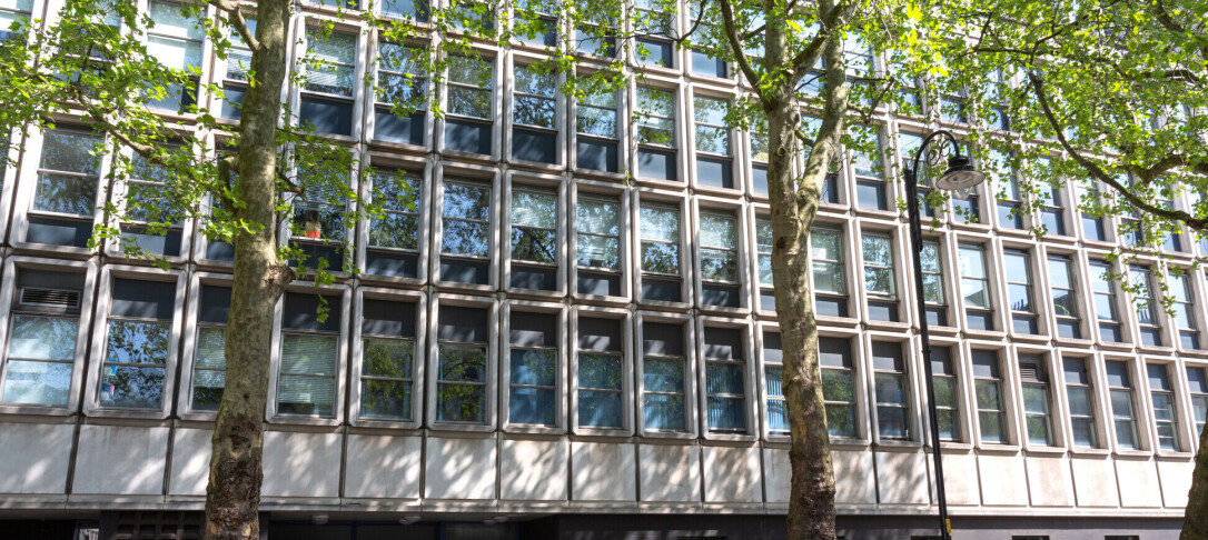 The Huxley building on a sunny day, a Zoomed photo showing the trees lining the street outside.