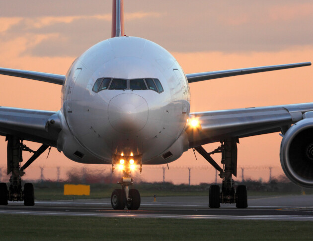 Image of an aeroplane on a runway at sunset