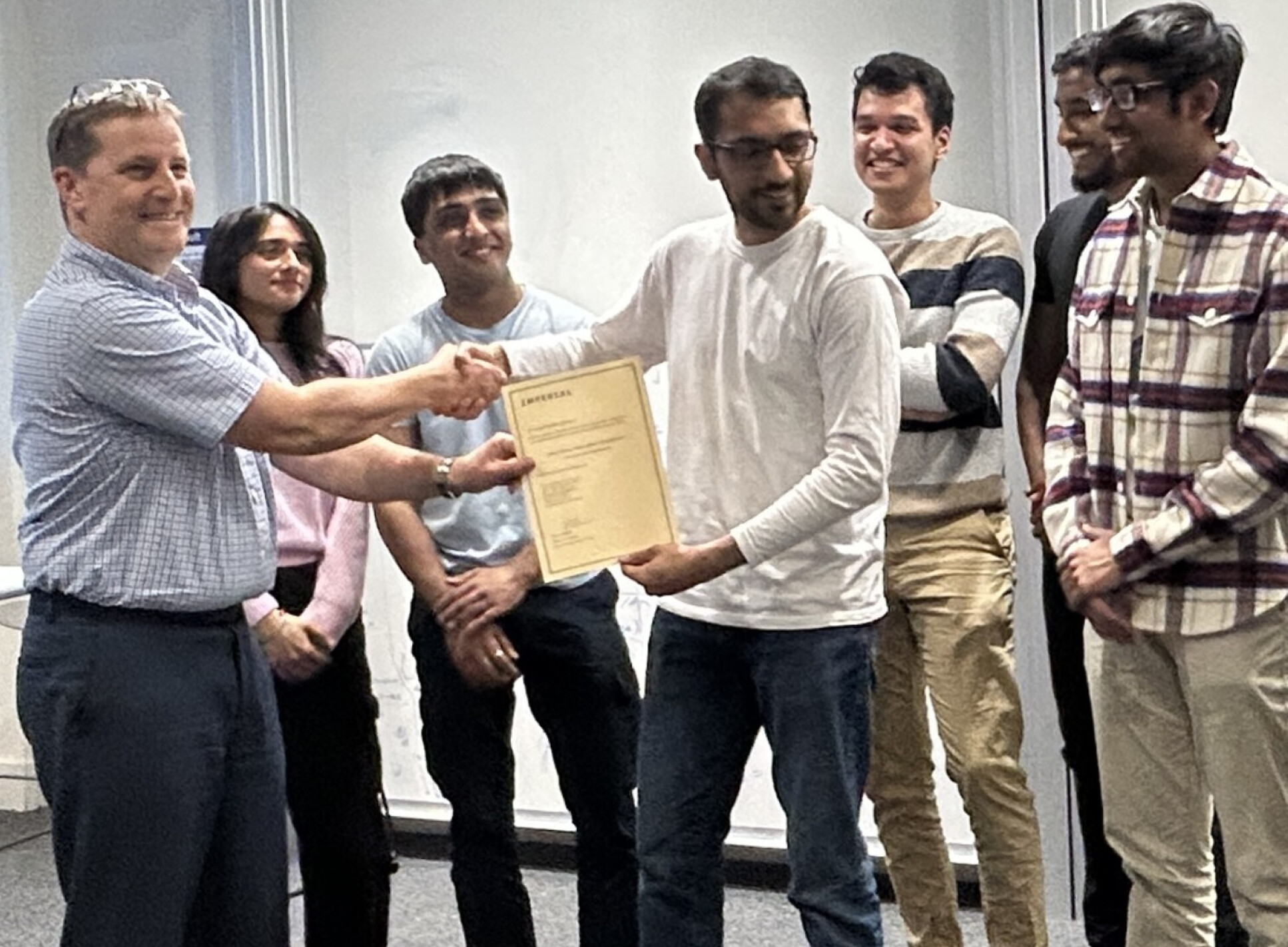 Dr Lee Shaw has presented the ‘Award for Best Optimization’ to MPT Coursework Group 5
