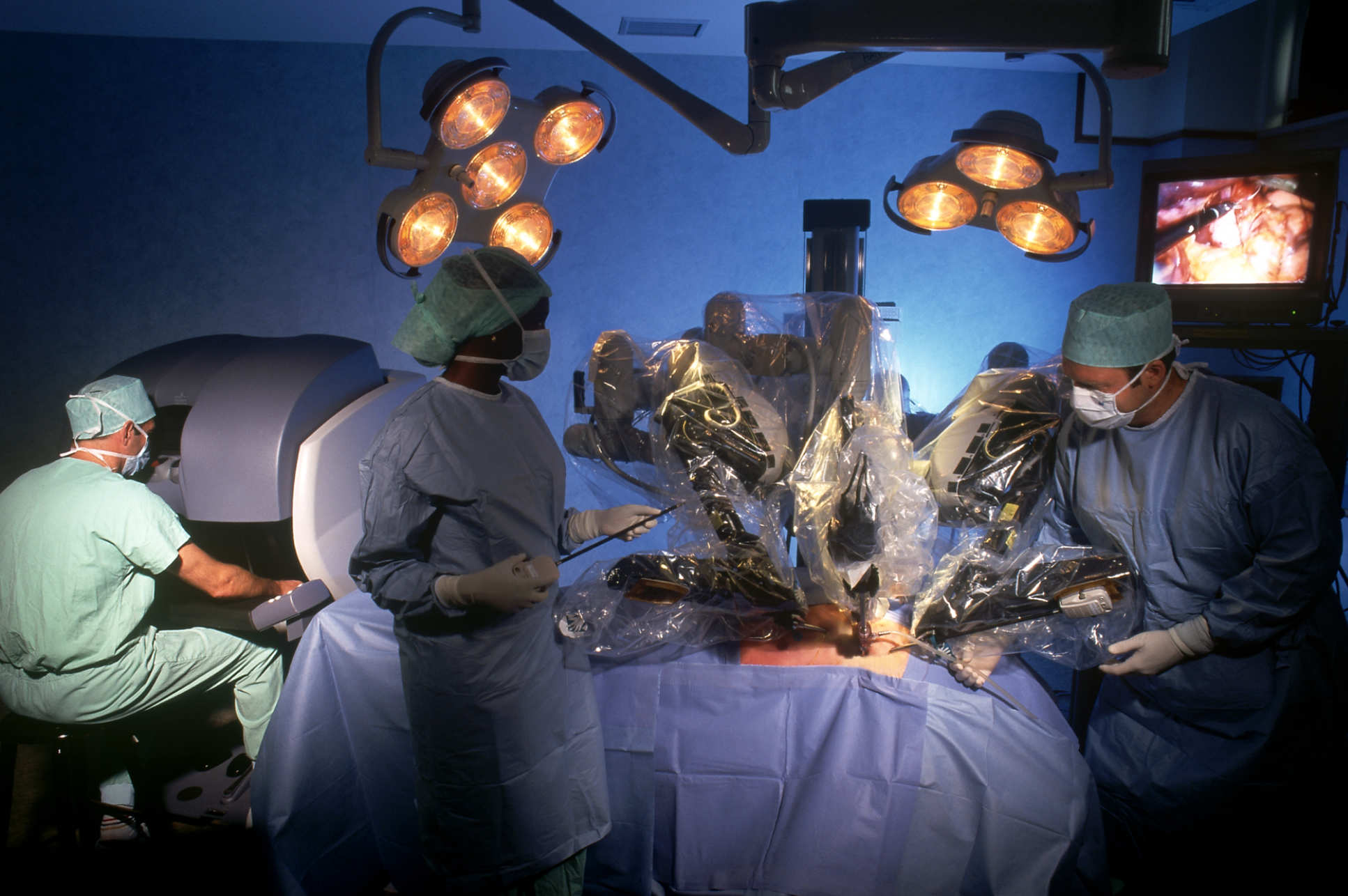 Robot arms over a patient in surgery