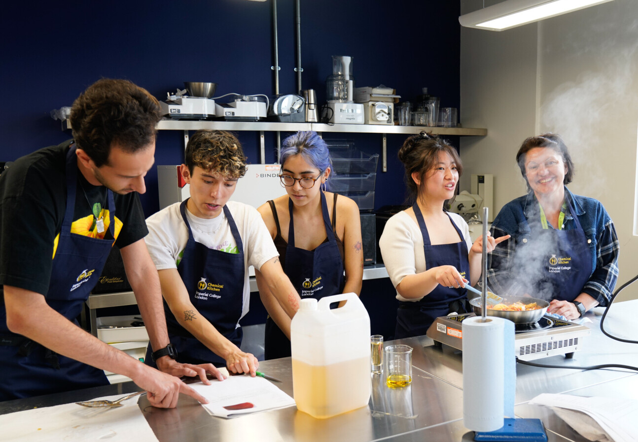 Students and staff in the kitchen cooking