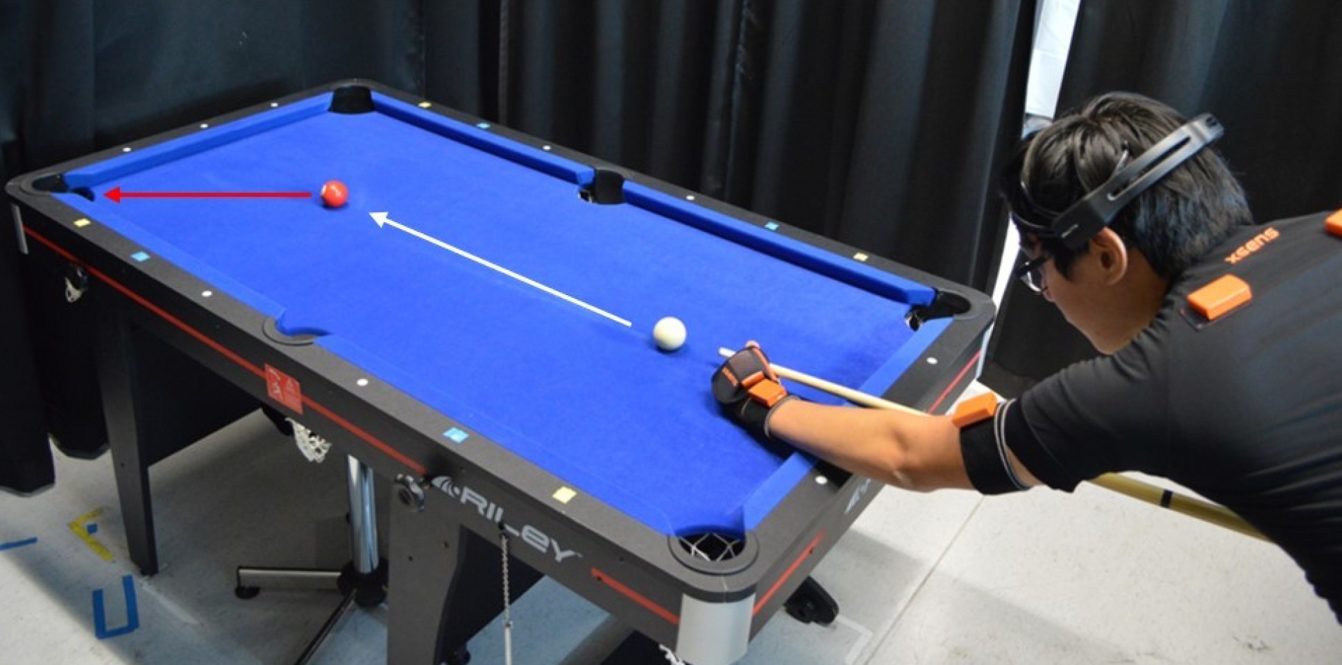 A study participant wearing motion sensors playing pool. 