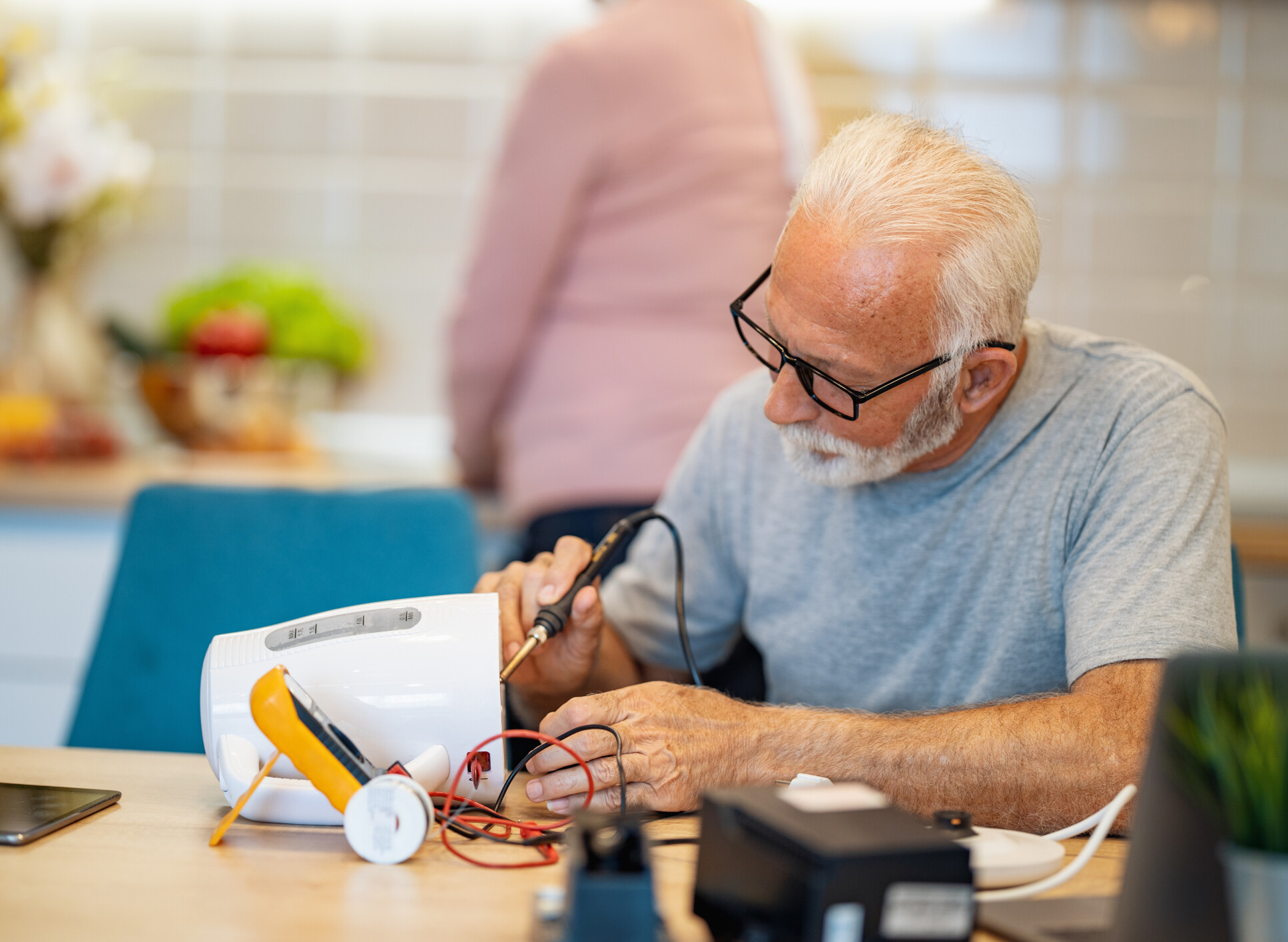 older man repairs a kettle