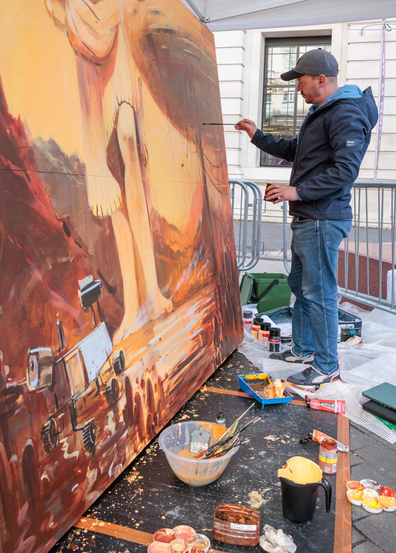Man painting orange and brown mural as part of Paint Lab