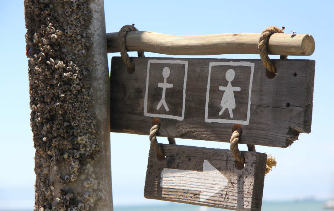 toilet signs on a wooden board