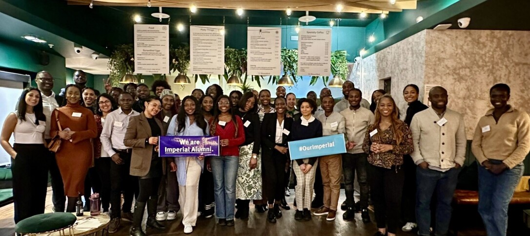 A group of over 30 alumni and Imperial staff at the last IBAN social event in March 2024. They are pictured in a restaurant/cafe gathered for the photo, smiling with a couple of banners held up that read: 'We are Imperial alumni.' and '#OurImperial'. 