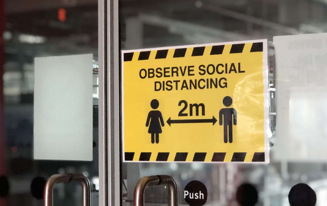 Sign reminding staff to observe social distancing