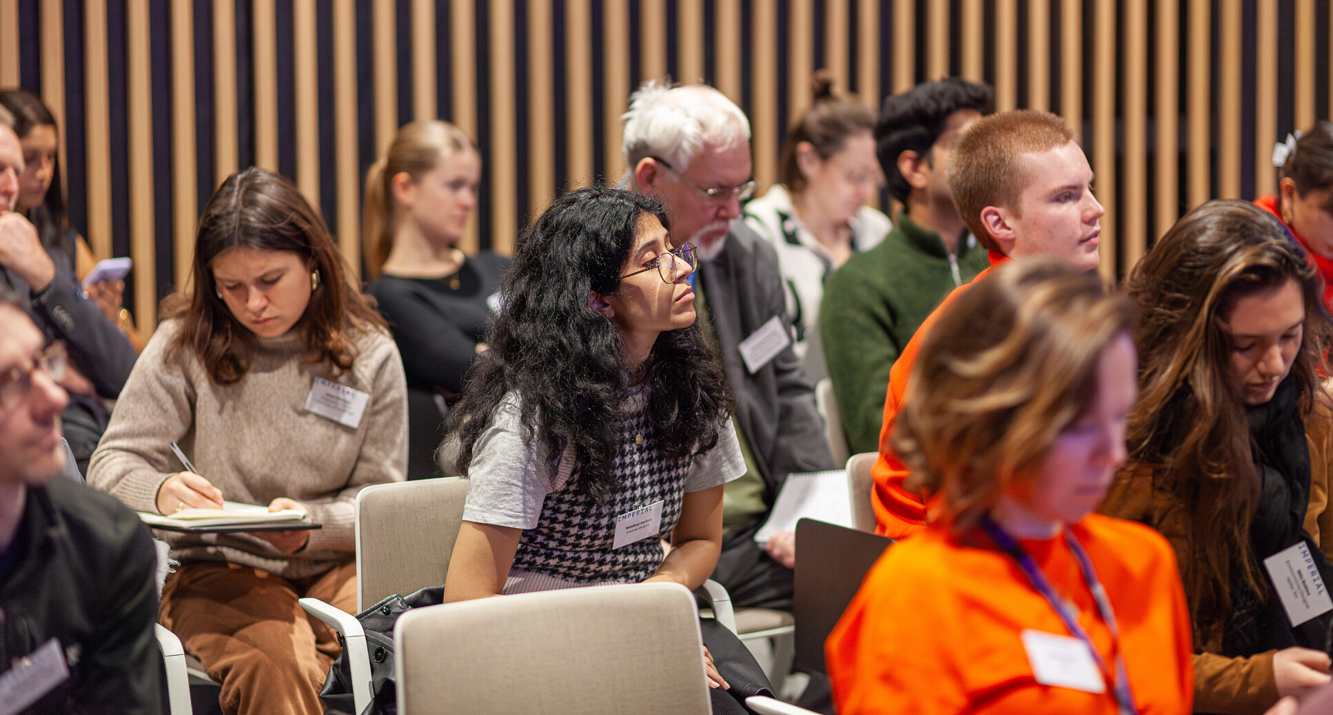 Attendees make notes during the panel discussion