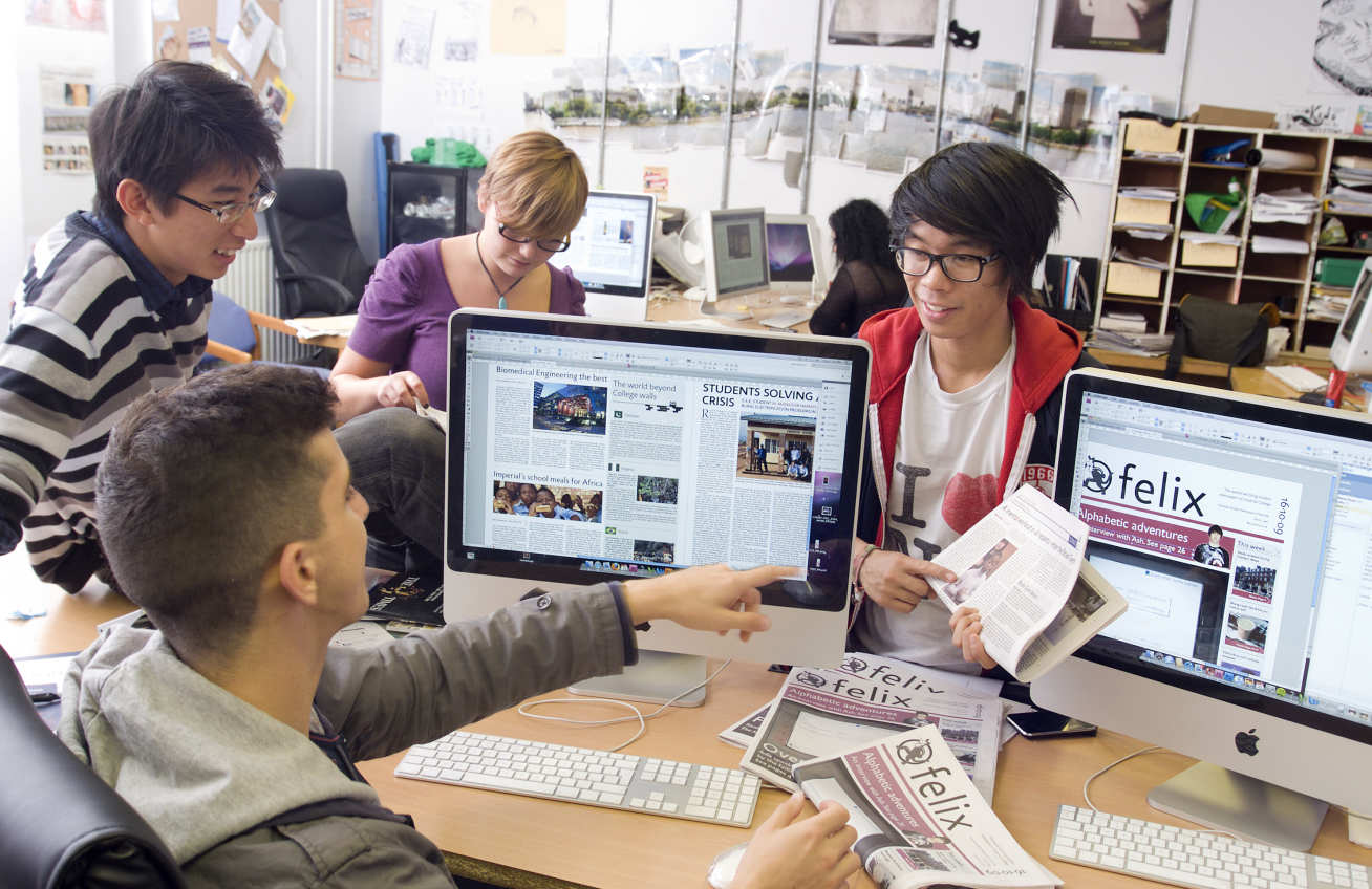 Student editors of Felix gather round a computer