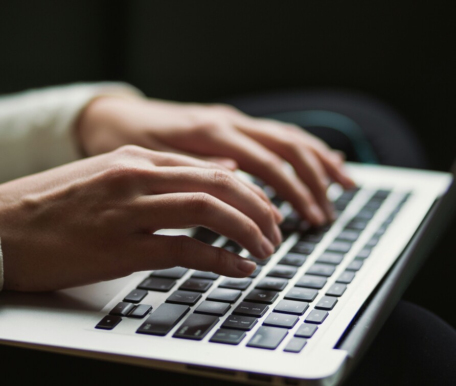 hands typing on laptop