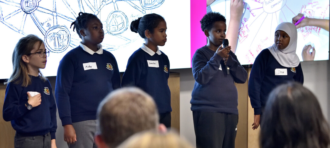 Group of young children speaking into microphone in front of audience