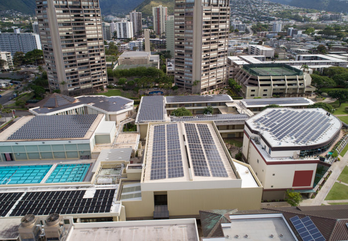 Aerial view of rooftops in a city covered in solar panels