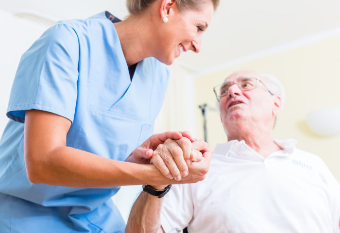 A female nurse caring for an elderly man