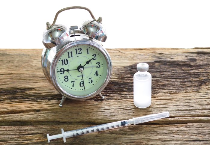 An alarm clock and a syringe