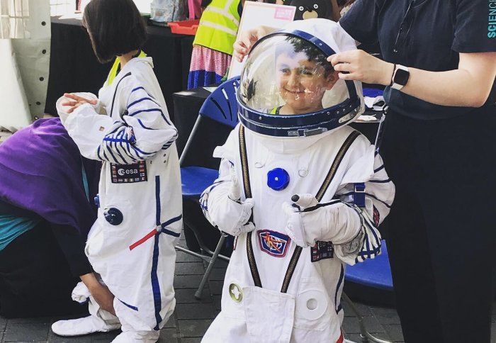 A young attendee of the Festival wears a space suit to dress up like an astronaut