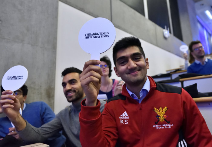 Student's holding small signs that have the 'The Times' newspaper logo