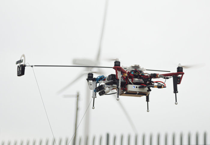 An autonomous drone in flight in front of a turbine