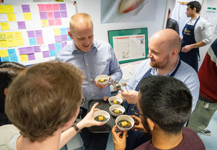 Guests enjoy a black squid ink risotto in the Chemical Kitchen