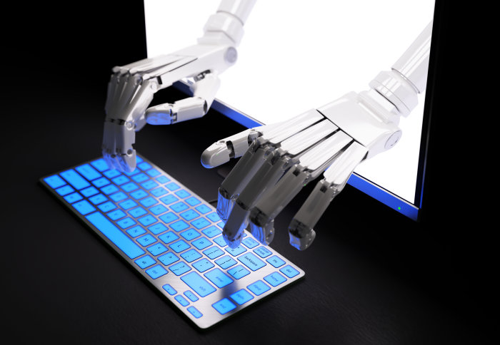 Robot hands reach out of screen to type on keyboard