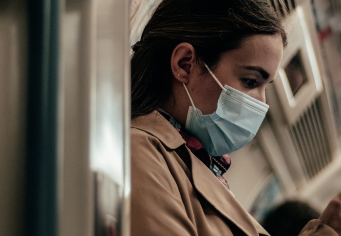 Woman on tube wearing a face mask