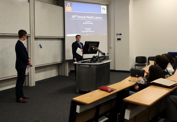 A man and a woman standing at the front of a lecture theatre